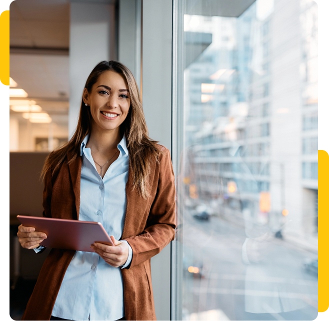 Woman at office looking to camera holding tablet